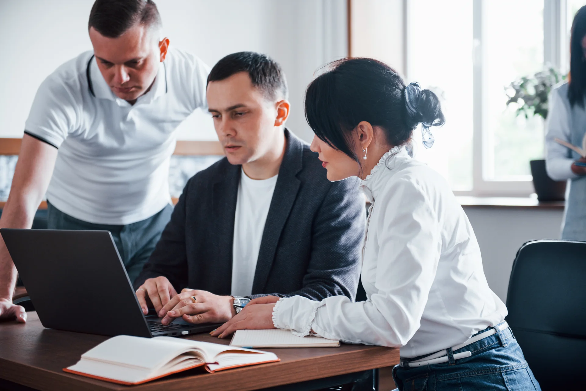 Equipo profesional colaborando frente a una computadora